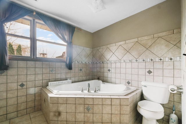 bathroom with tile patterned floors, tiled bath, tile walls, and toilet