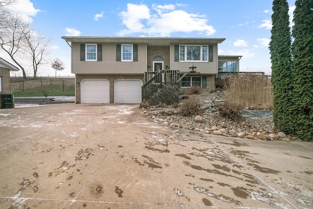 bi-level home featuring cooling unit and a garage