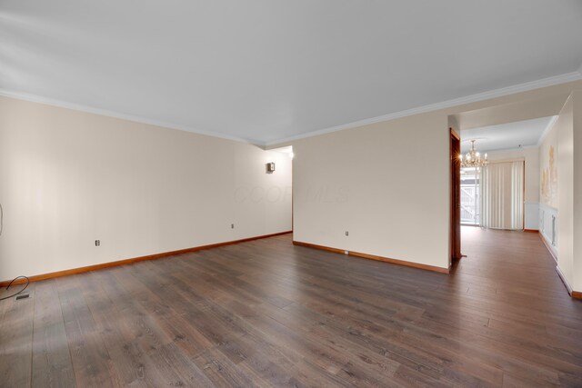 empty room with ornamental molding, dark hardwood / wood-style flooring, and a notable chandelier