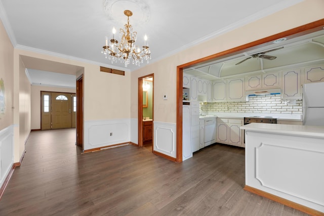 kitchen featuring dark hardwood / wood-style flooring, white appliances, crown molding, and hanging light fixtures