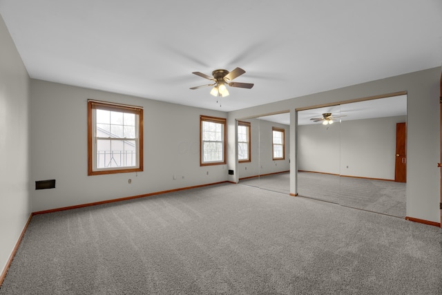 carpeted spare room with ceiling fan