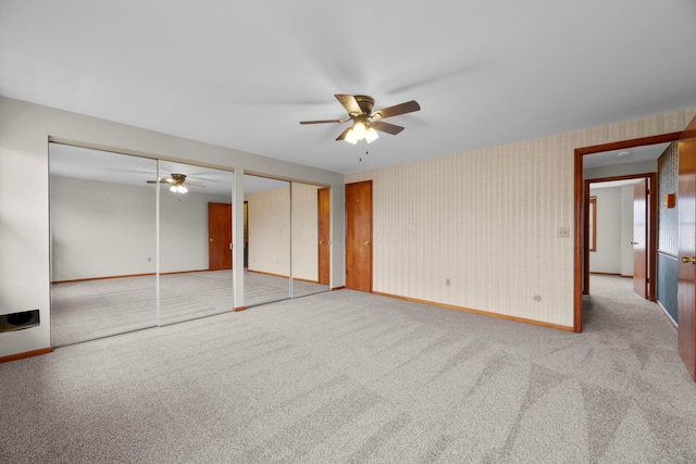 interior space featuring two closets, ceiling fan, and carpet