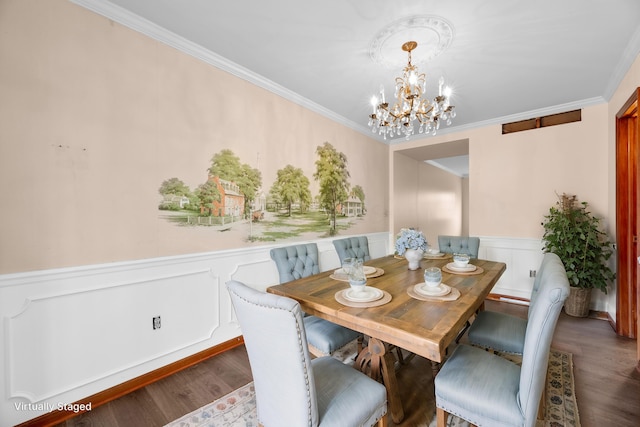 dining space featuring a chandelier, crown molding, and wood-type flooring