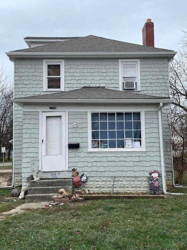 view of front of house featuring a front yard and cooling unit