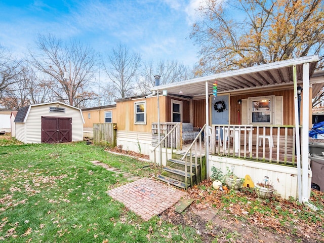 view of front facade featuring covered porch, a shed, and a front lawn