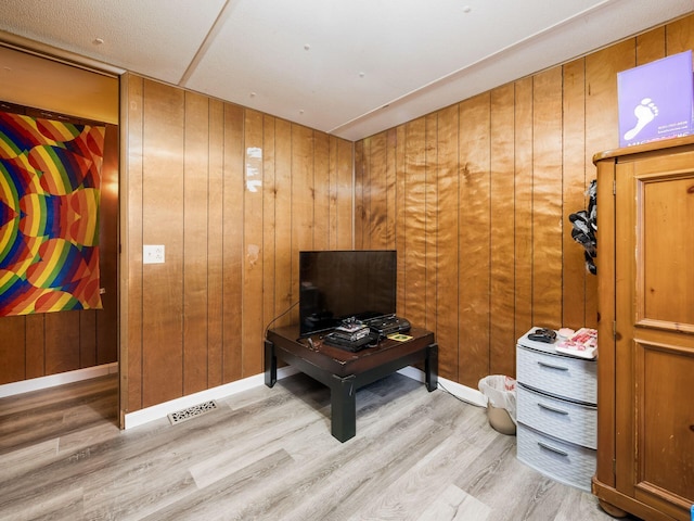 interior space featuring wood-type flooring and wooden walls