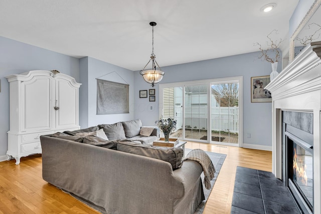 living room featuring a tiled fireplace and hardwood / wood-style floors