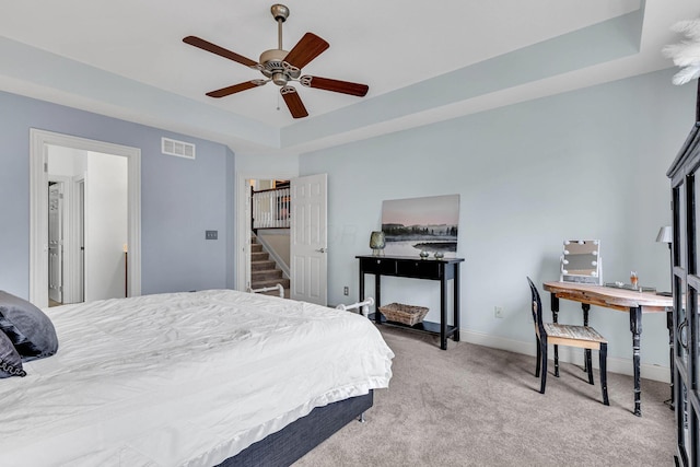 bedroom featuring carpet floors, ceiling fan, and a tray ceiling