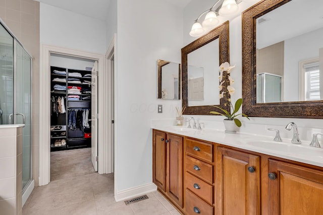 bathroom with vanity, a shower with shower door, and tile patterned floors