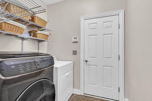 laundry area featuring dark tile patterned flooring and washer and dryer