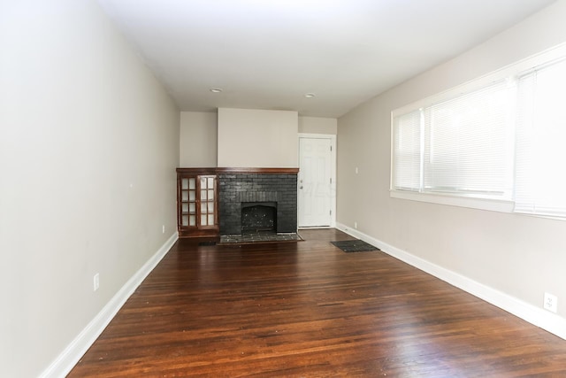 724 S Eureka Ave, Columbus, OH 43204 - unfurnished living room featuring dark wood-style floors and a fireplace