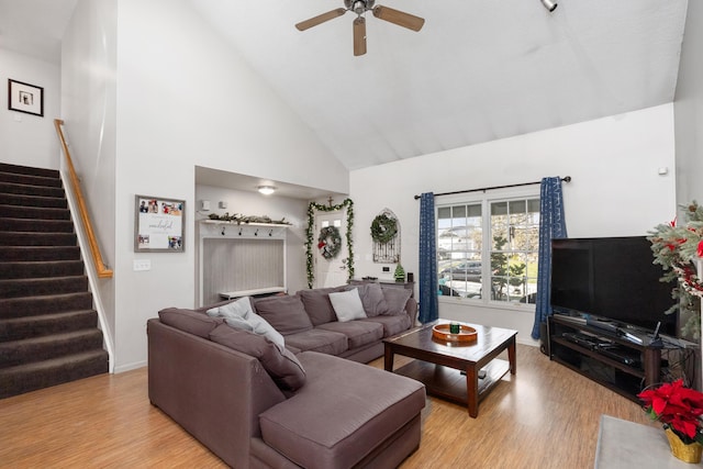 living room featuring light hardwood / wood-style flooring, high vaulted ceiling, and ceiling fan