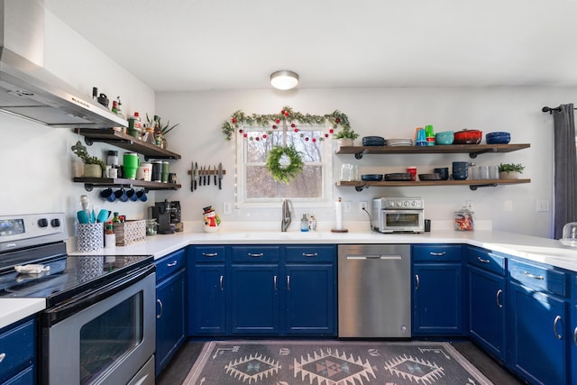 kitchen featuring sink, stainless steel appliances, blue cabinets, and wall chimney range hood