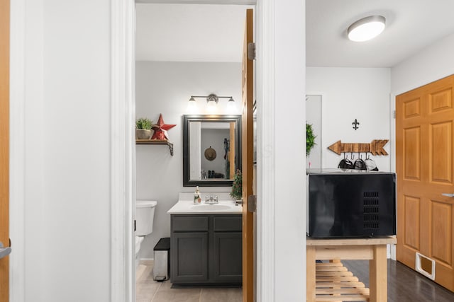 bathroom with hardwood / wood-style floors, vanity, and toilet