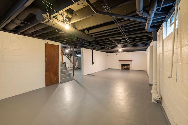 basement featuring a brick fireplace and water heater