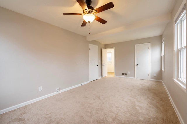 carpeted spare room featuring ceiling fan