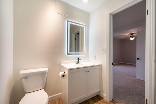 bathroom with vanity, toilet, and ceiling fan