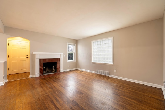 unfurnished living room featuring a fireplace and dark hardwood / wood-style flooring