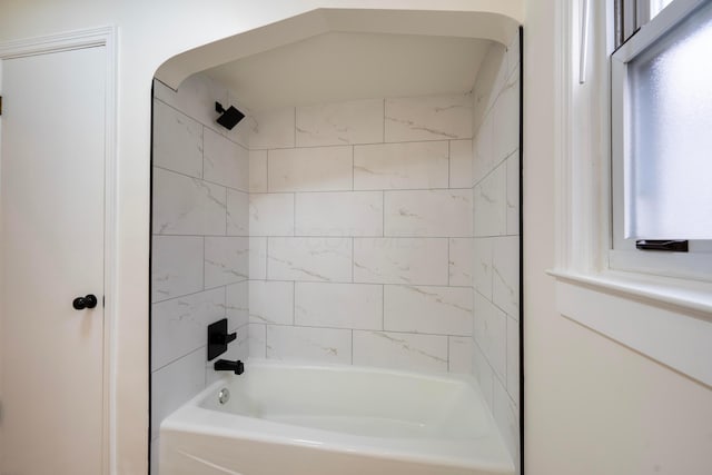 bathroom with a wealth of natural light and tiled shower / bath combo