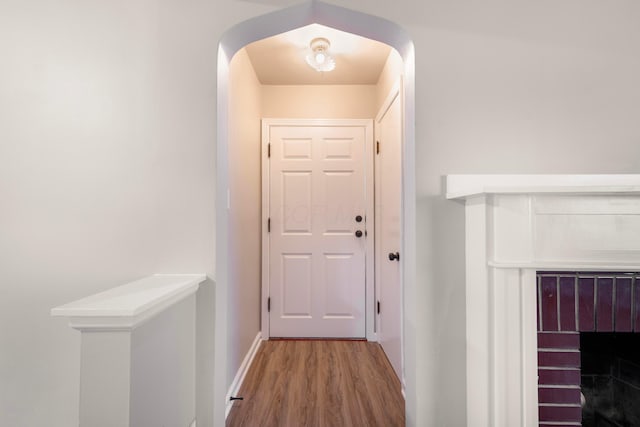 doorway to outside with a fireplace and wood-type flooring