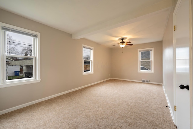 carpeted empty room featuring ceiling fan and beamed ceiling