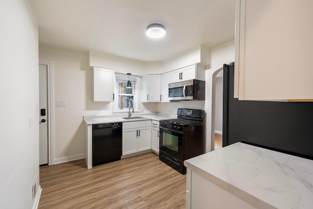 kitchen featuring white cabinets, sink, light hardwood / wood-style floors, and black appliances