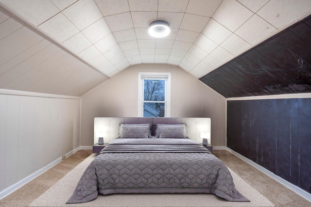 bedroom with light carpet, wood walls, and lofted ceiling