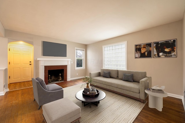 living room featuring wood-type flooring and a brick fireplace