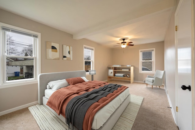 bedroom featuring ceiling fan, beamed ceiling, and light colored carpet