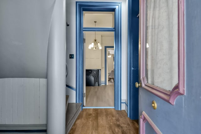 hallway with radiator and a chandelier