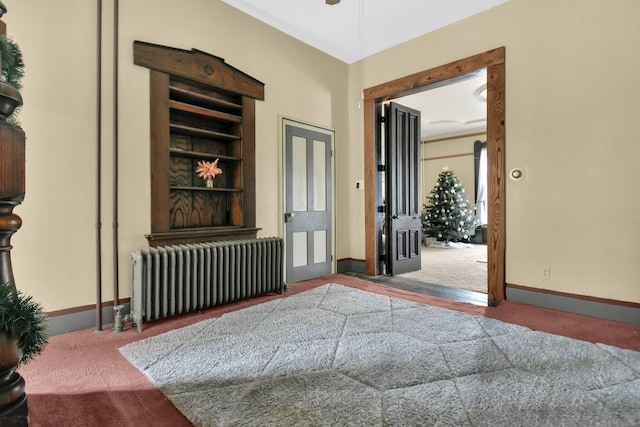 carpeted living room with radiator and built in features