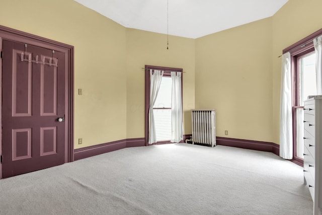 empty room featuring light carpet and radiator