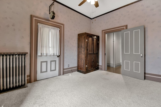 unfurnished bedroom featuring carpet flooring, ceiling fan, radiator heating unit, and ornamental molding