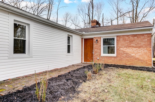 view of exterior entry with a lawn