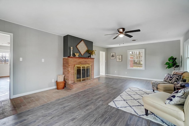 living room featuring ceiling fan, dark wood-type flooring, and a brick fireplace