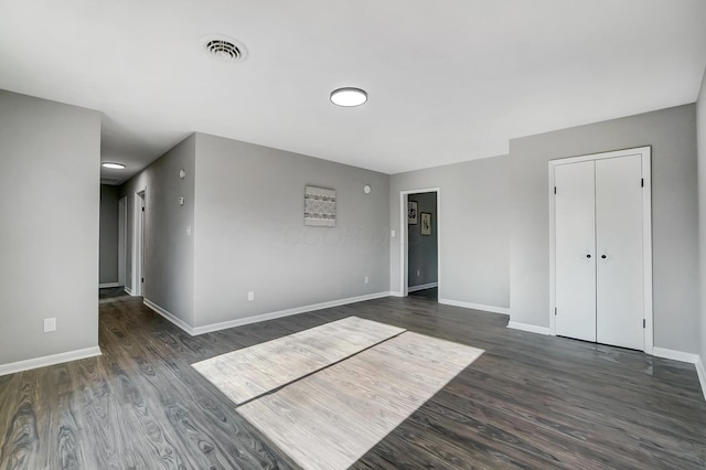 empty room with dark hardwood / wood-style flooring