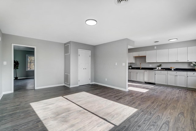 kitchen with dishwasher, sink, white cabinetry, and dark wood-type flooring