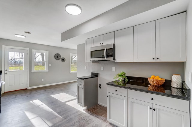 kitchen featuring dark stone countertops, white cabinetry, and light hardwood / wood-style floors