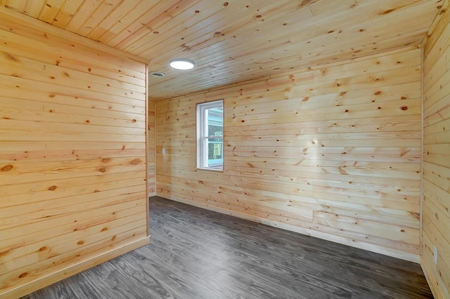 empty room with wood walls, dark wood-type flooring, and wooden ceiling