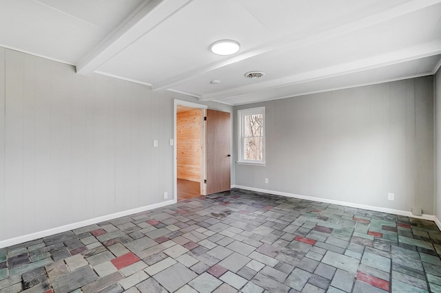 unfurnished room with beam ceiling and wooden walls