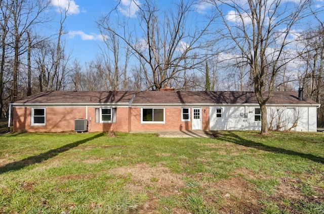 rear view of house with cooling unit and a yard