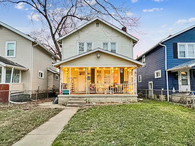 back of house featuring a porch and a lawn