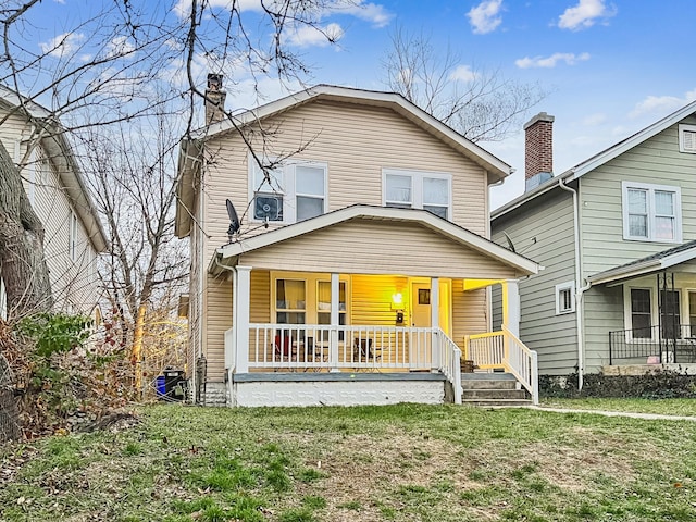 view of front of home with a porch and a front lawn