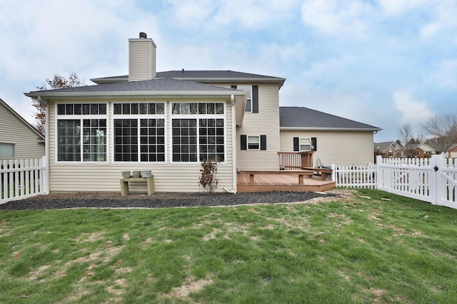 back of property with a lawn and a deck