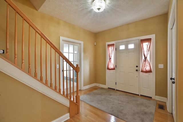 entrance foyer featuring a textured ceiling and light hardwood / wood-style floors