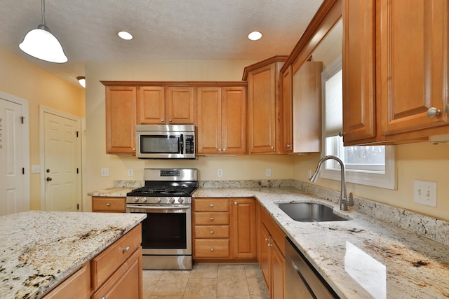 kitchen featuring sink, light stone counters, decorative light fixtures, light tile patterned flooring, and appliances with stainless steel finishes