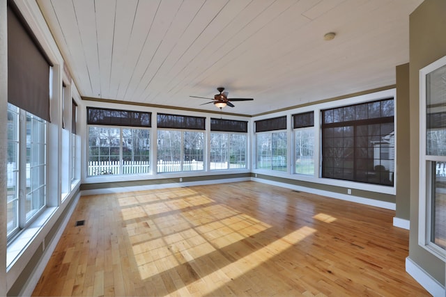 unfurnished sunroom featuring a wealth of natural light, ceiling fan, and wood ceiling