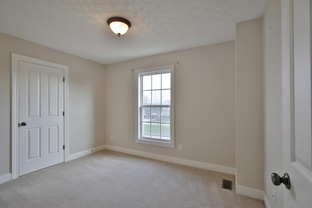 carpeted spare room with a textured ceiling