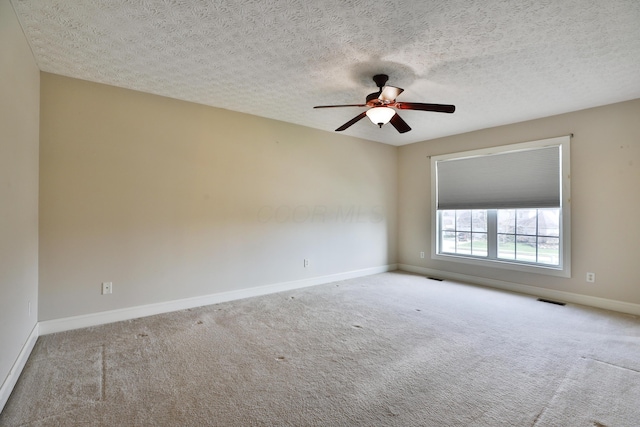 carpeted spare room with ceiling fan and a textured ceiling