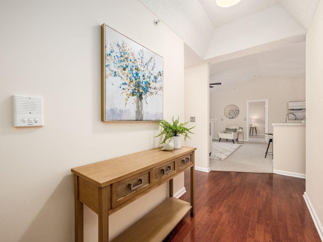 hallway featuring dark wood-type flooring and lofted ceiling